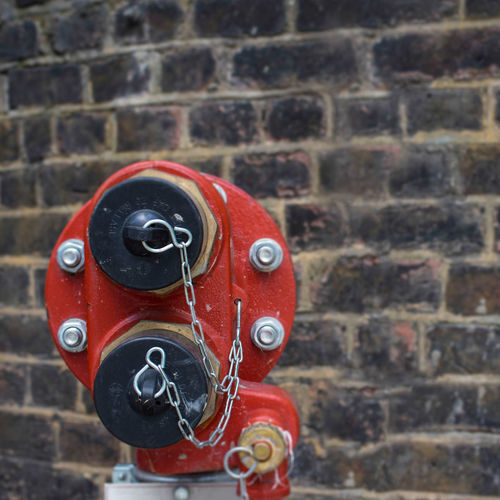 Close-up of rusty chain on brick wall