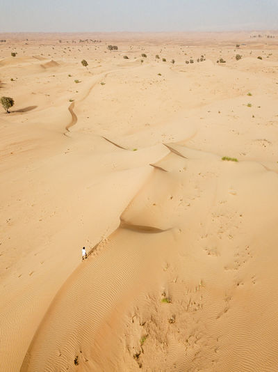 One person walking on sand dunes in desert