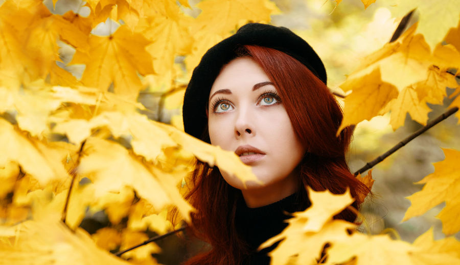Portrait of young woman with autumn leaves