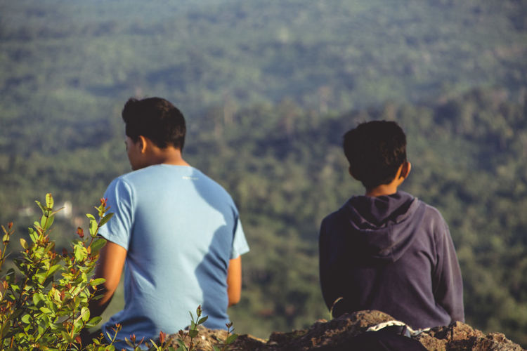 Rear view of men sitting outdoors