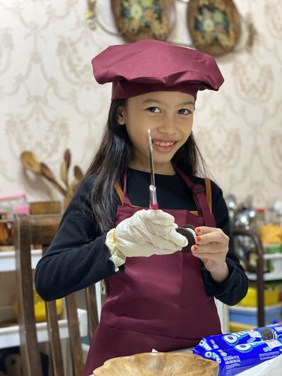 Portrait of happy girl wearing a chef attire 