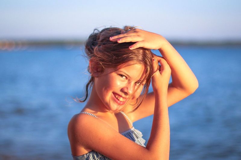 Portrait of smiling girl by sea