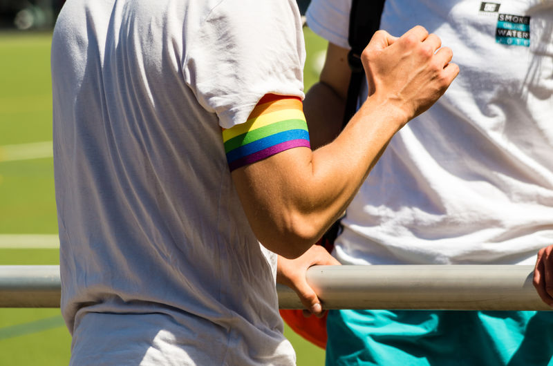 Midsection of man wearing rainbow flag band