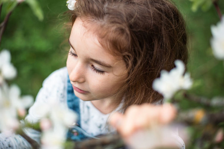 Close-up of cute girl playing with flowers