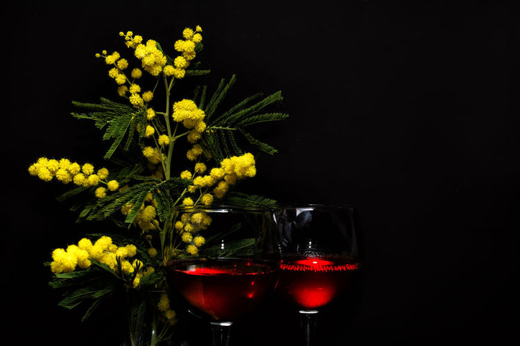 Close-up of red wine glass against black background
