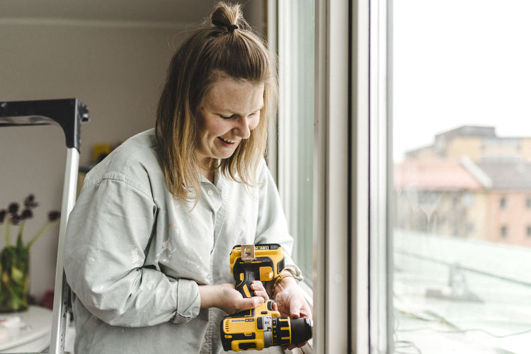 Woman using electric drill