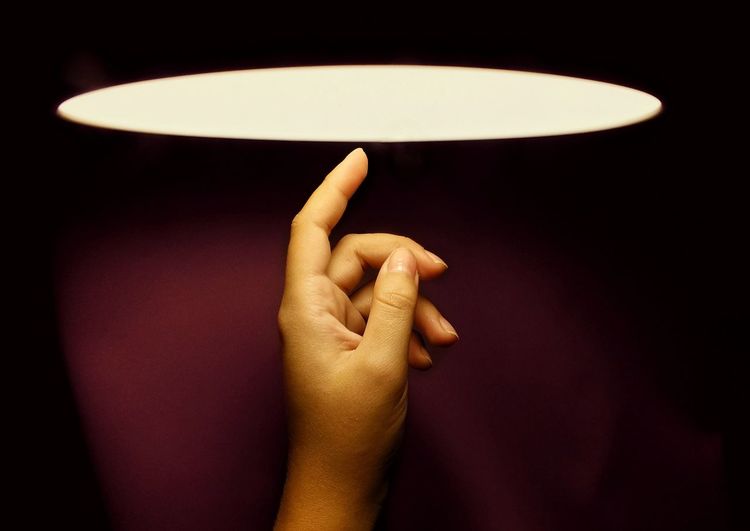 Close-up of hand holding illuminated lamp