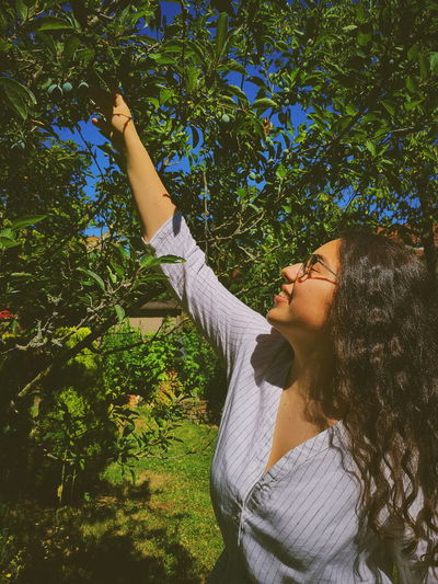 Woman harvesting fruits growing on trees