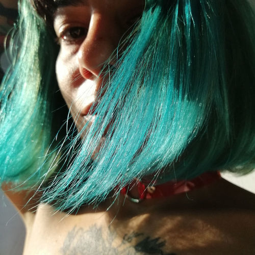 Close-up portrait of woman with green hair