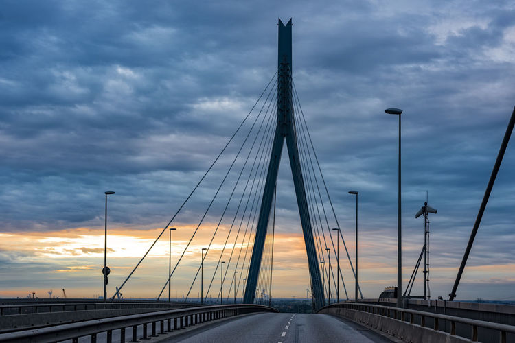 Bridge against cloudy sky at sunset