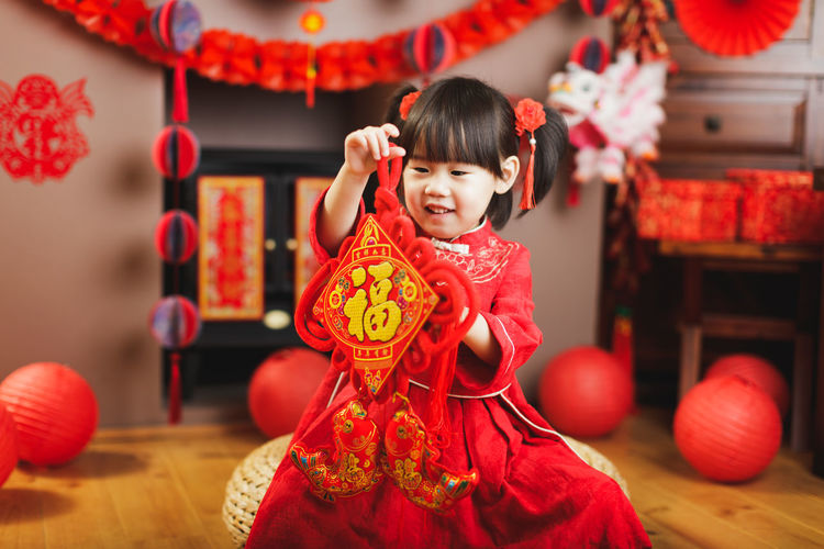 Smiling girl in traditional clothing holding decoration