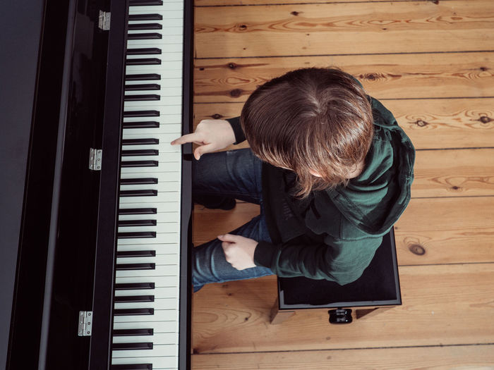 High angle view of boy playing piano at home