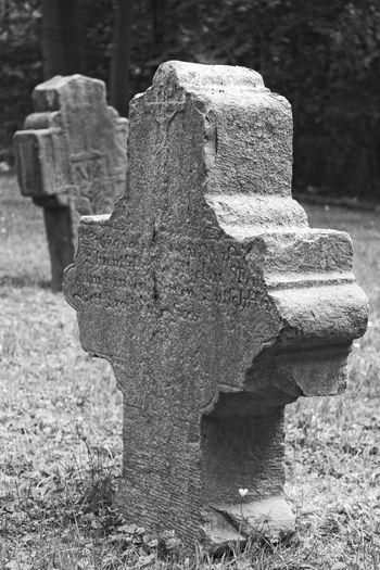 Close-up of stone cross in cemetery