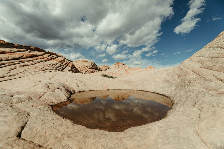 Post rain puddle and reflection of red rock petrified sand dunes