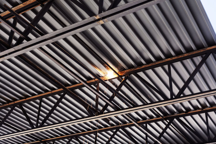 Low angle view of sparks emitting from girders at construction site