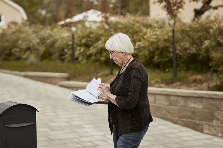 Senior woman standing near mailbox