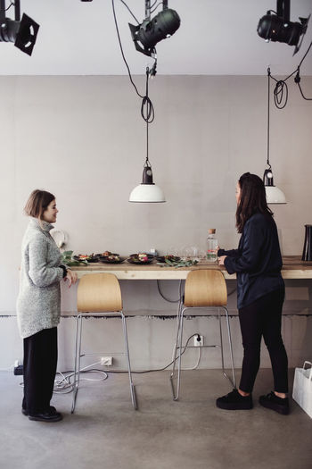 SIDE VIEW OF WOMEN SITTING IN CAFE