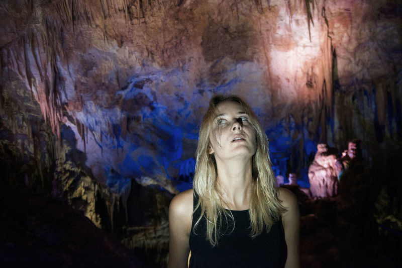 Young woman looking up while standing in cave