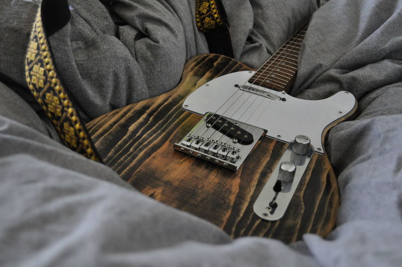 High angle view of guitar over textile