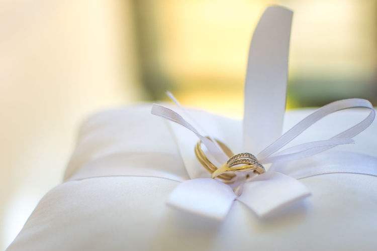 Close-up of wedding rings on pillow at home