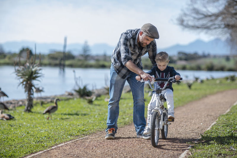 Father supporting son on bike