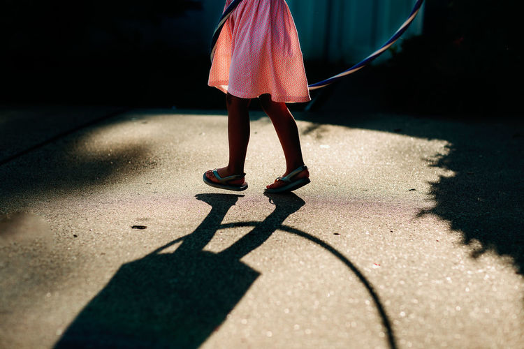 Low section of girl walking on street