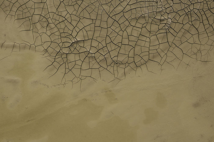 High angle view of sand by cracked field