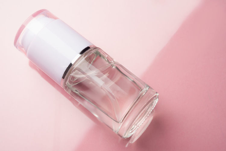 Transparent dispenser bottle with cosmetic product for face and body. beauty concept.