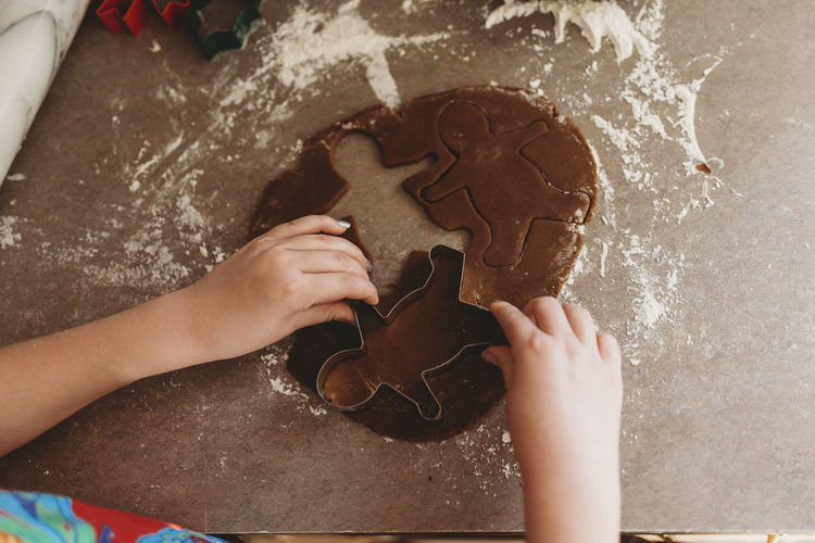 Close up of child's hands making gingerbread men cookies