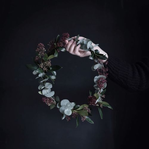 Man wearing flowers against black background