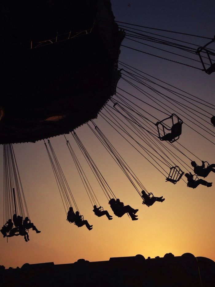 Low angle view of silhouette swing ride against clear sky