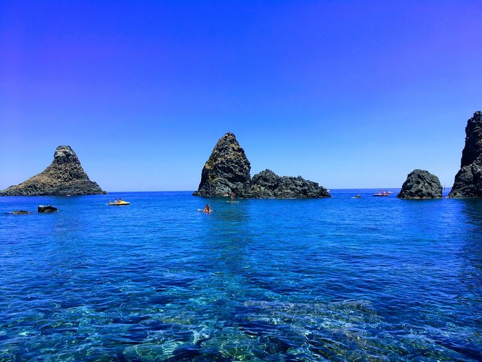 Panoramic view of sea against clear blue sky and sea stones