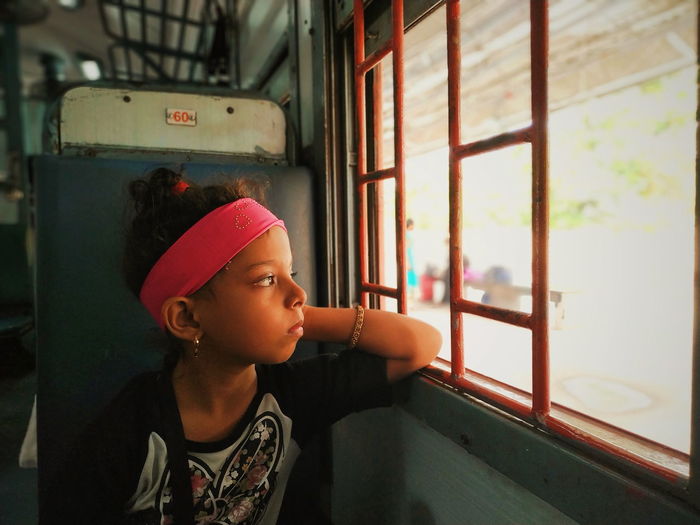 Girl looking through train window