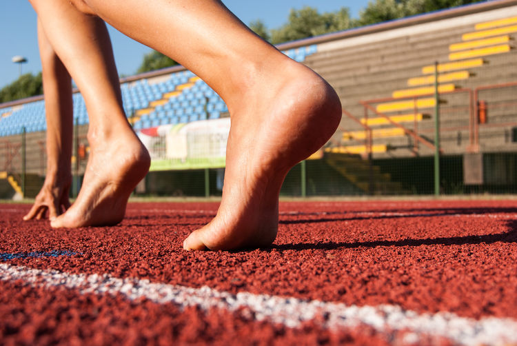 Low section of man running at sports track