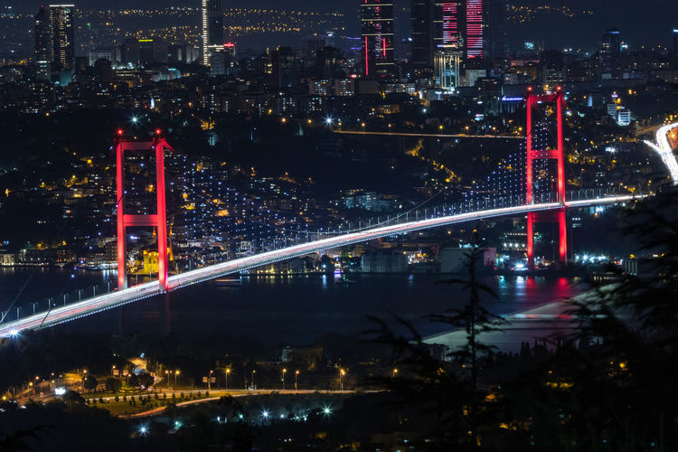 High angle view of illuminated bridge and buildings at night