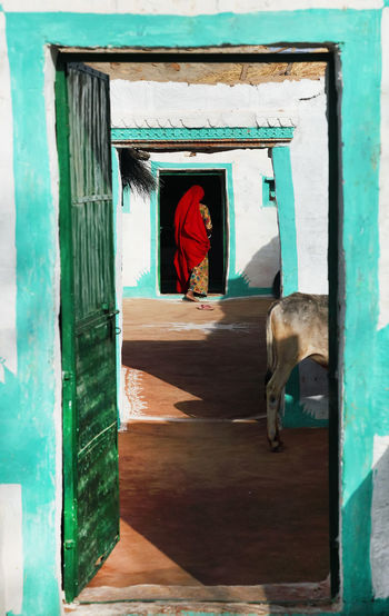 Rear view of woman walking into doorway