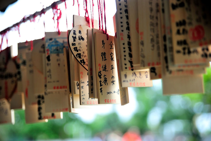 Close-up of wooden labels with text hanging outdoors