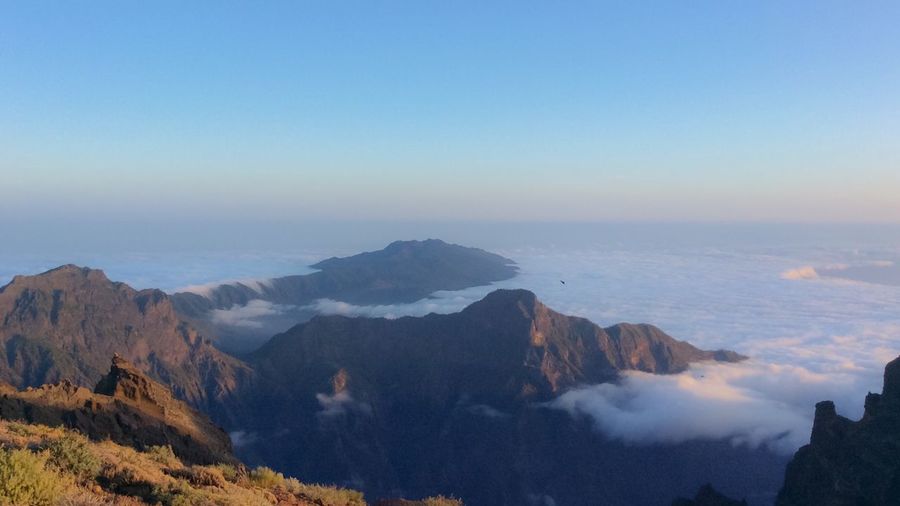 Scenic view of sea and mountains against clear sky