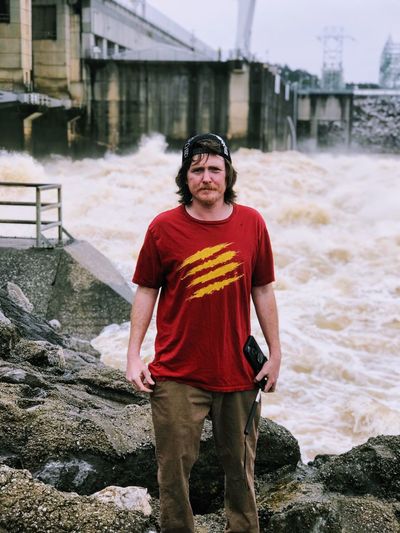 Portrait of man standing against dam