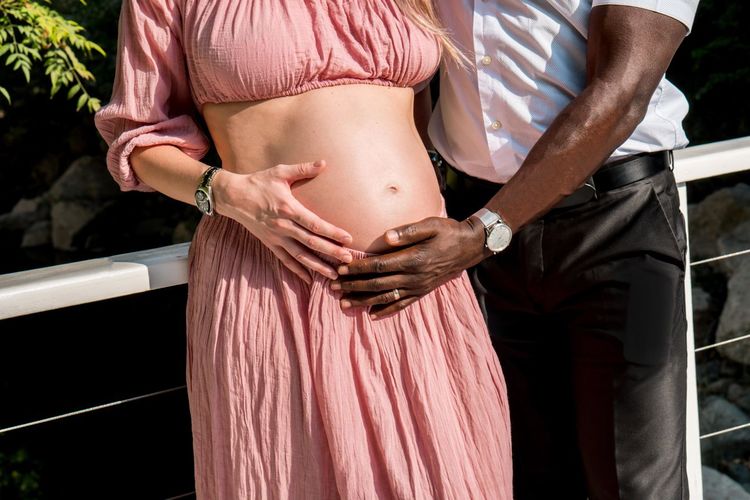 Midsection of man with pregnant woman