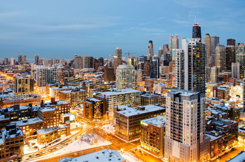Illuminated cityscape during winter against sky
