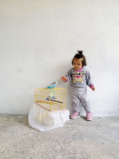Full length of cute baby sitting on wall