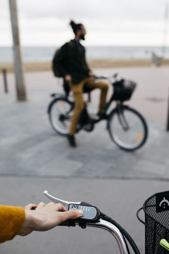 Close-up of woman on e-bike connecting the electric motor with man in background
