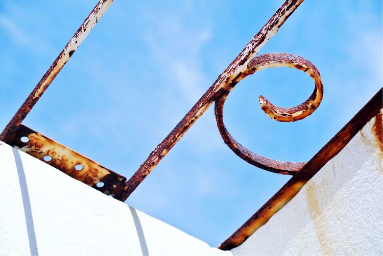 Low angle view of rusty chain against sky