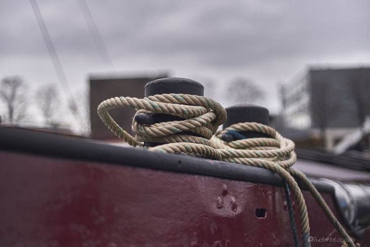 Close-up of rope tied at harbor