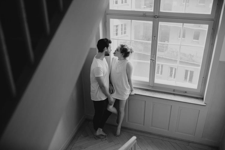 Rear view of couple standing against window