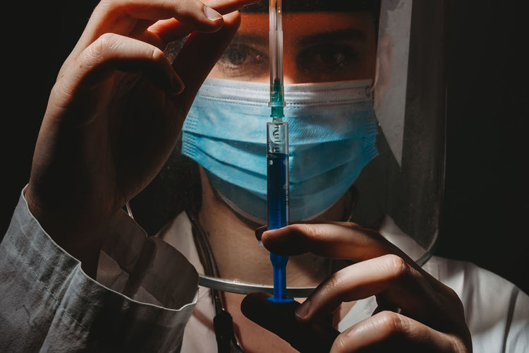 Close-up portrait of doctor holding syringe