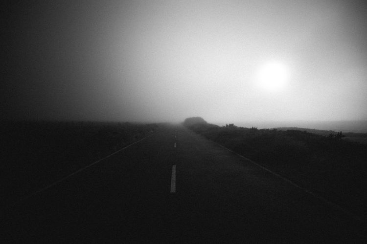 Scenic view of road against sky during foggy weather