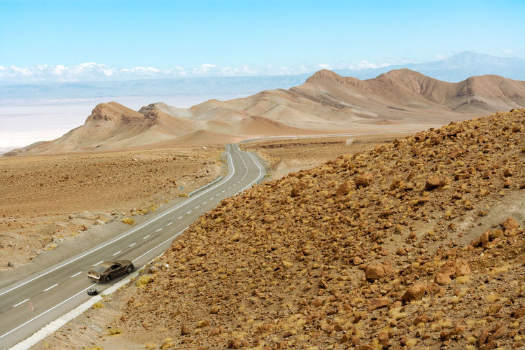 Scenic view of desert road against sky