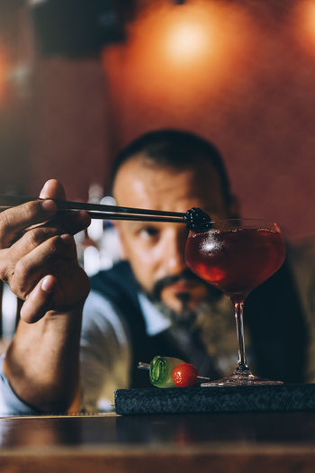 Mature bartender preparing cocktail on bar counter